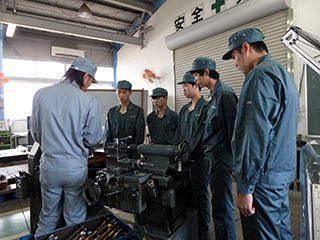 旋盤作業の説明を聞く様子