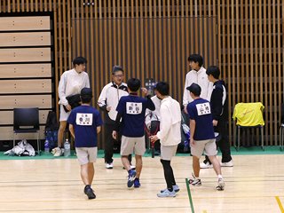 チェンジコートで意気揚々と帰陣する選手たちを迎える監督