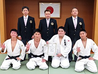 阿賀体育協会柔道競技者の 皆さんと記念撮影： 前列左から加計さん、大久保選手、 村岡さん、阿河選手、 後列左から平野顧問、 宮本阿賀体協チーム監督、 黒木課外活動指導員