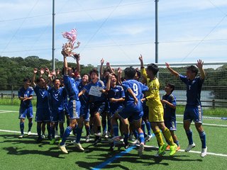 優勝カップをもって動画を撮っています