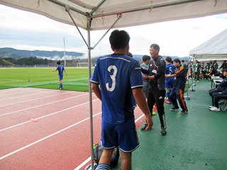 ピッチ入りする選手を激励しています