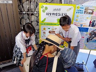 微生物発電の展示説明をしている様子